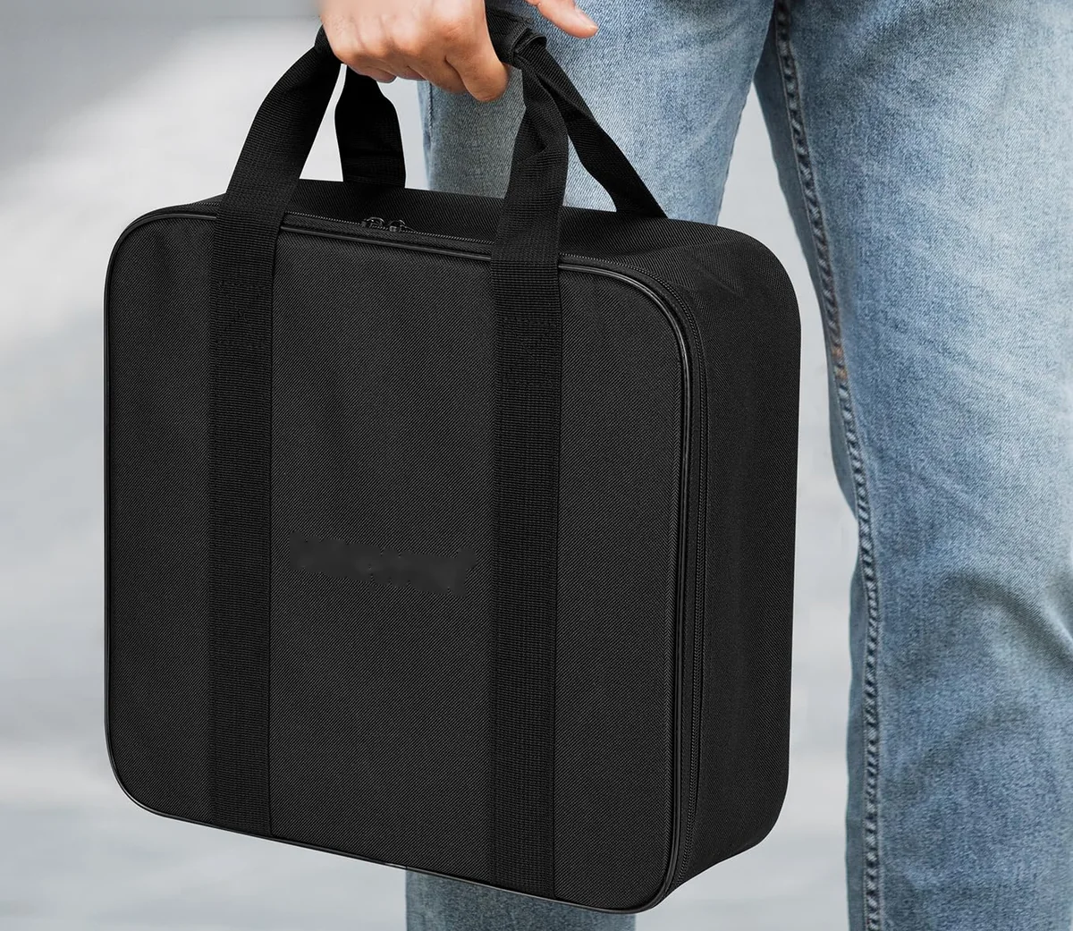 The padded carry case, held by its handles